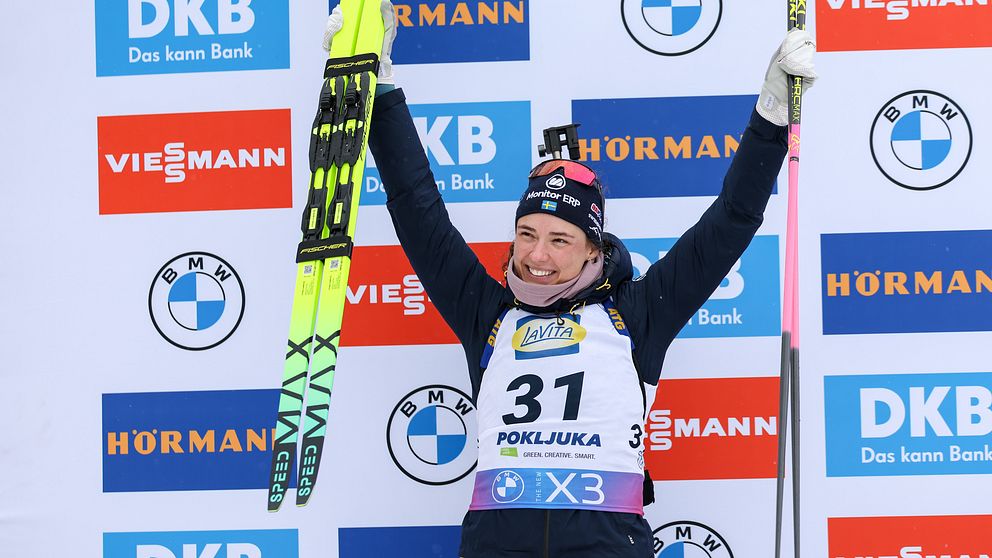 Skidskytten Hanna Öberg sträcker upp armarna i en segergest under prisutdelningen.