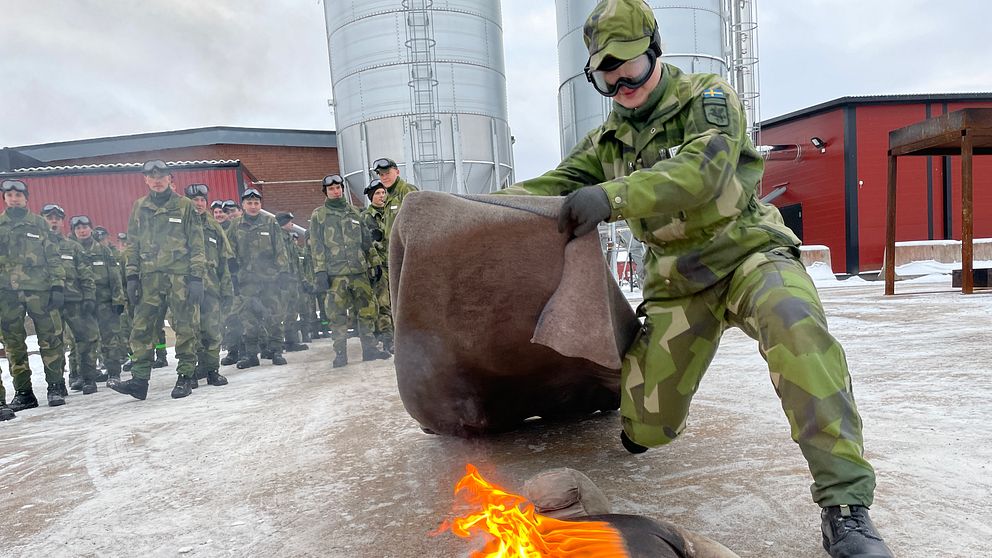 Soldat släcker brinnande docka med napalm på sig