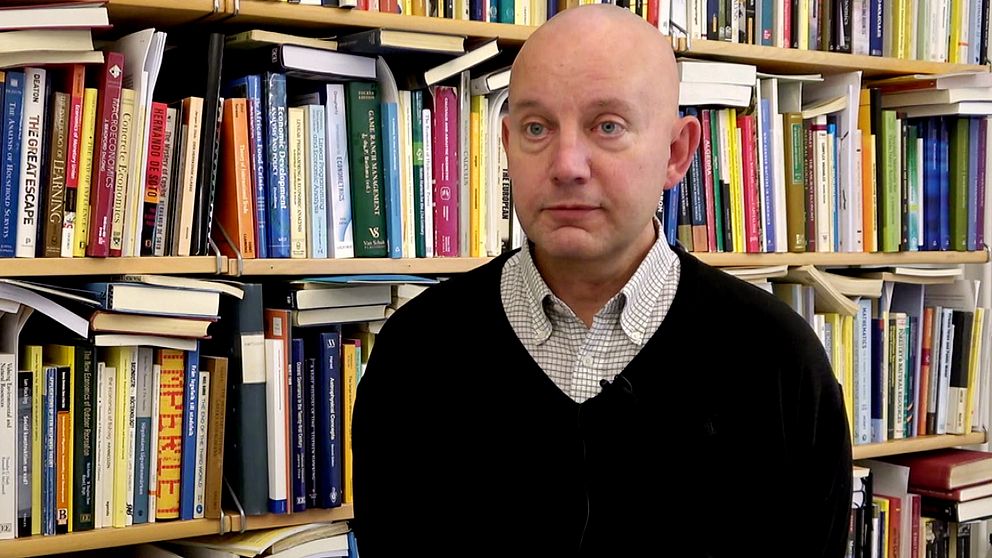 Nationalekonomen Jesper Stage står framför en bokhylla.