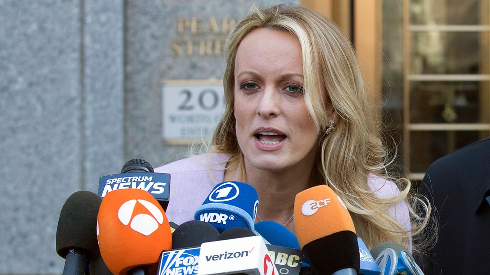 Stormy Daniels pratar framför journalister om åtalet mot Donald Trump.