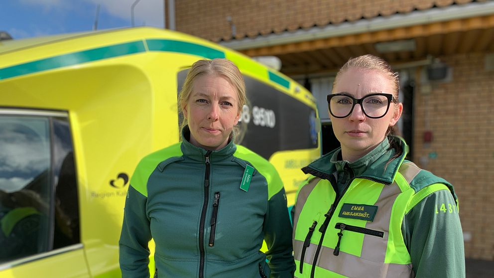 Två kvinnliga ambulanssjuksköterskor står framför ambulans.