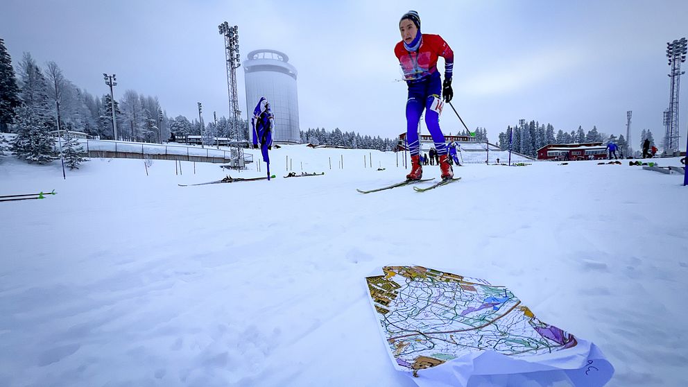 En kille åker skidor med ett kartställ, skidorientering, på Östersunds skidstadion.