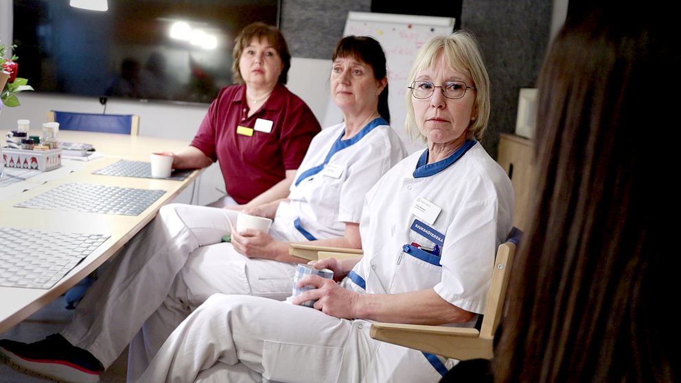 Tre sjuksköterskor sitter vid ett bord och tittar på reportern.