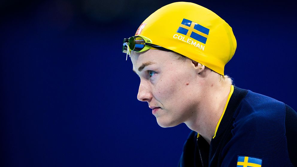 Simhoppare i gul simmössa med svenska flaggan.