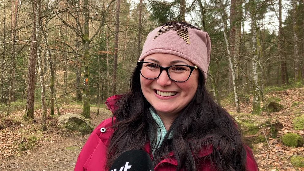 Erika Balogh står i skogen framför några granar vid Danska fallet