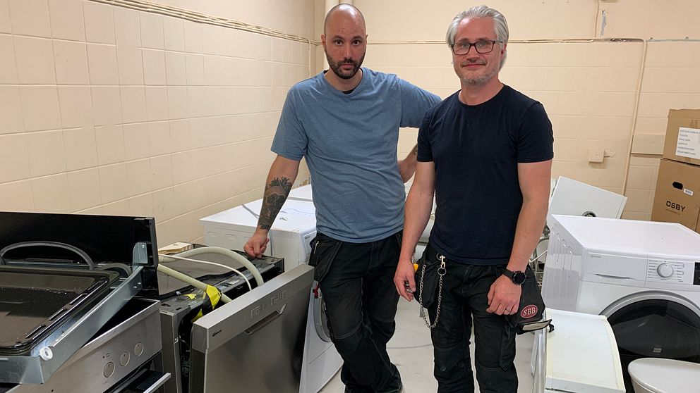 Fastighetsteknikerna Joakim Hedenskog och Daniel Iversen står i en förrådslokal.