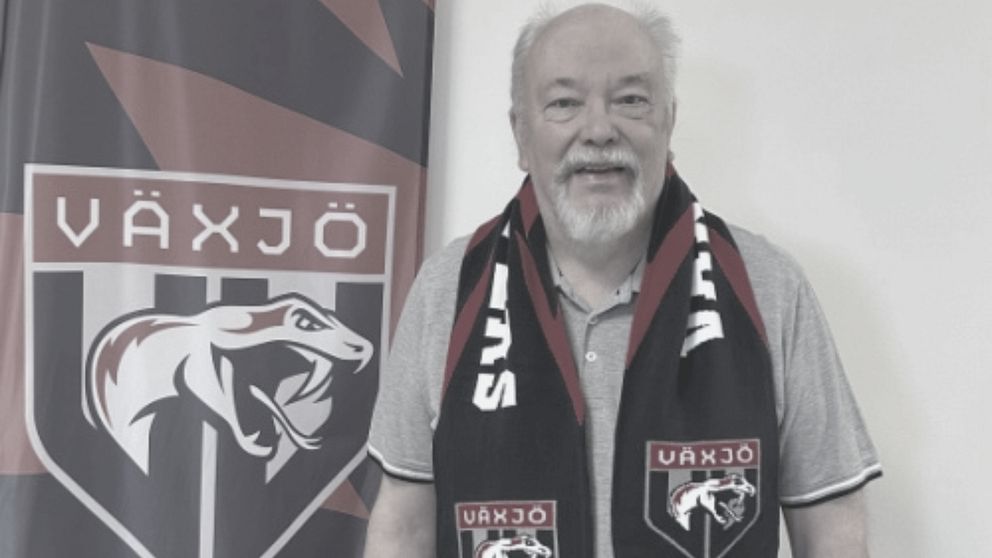 Person bär Växjö-supporterscarf framför klubbens logotyp på en flagga.