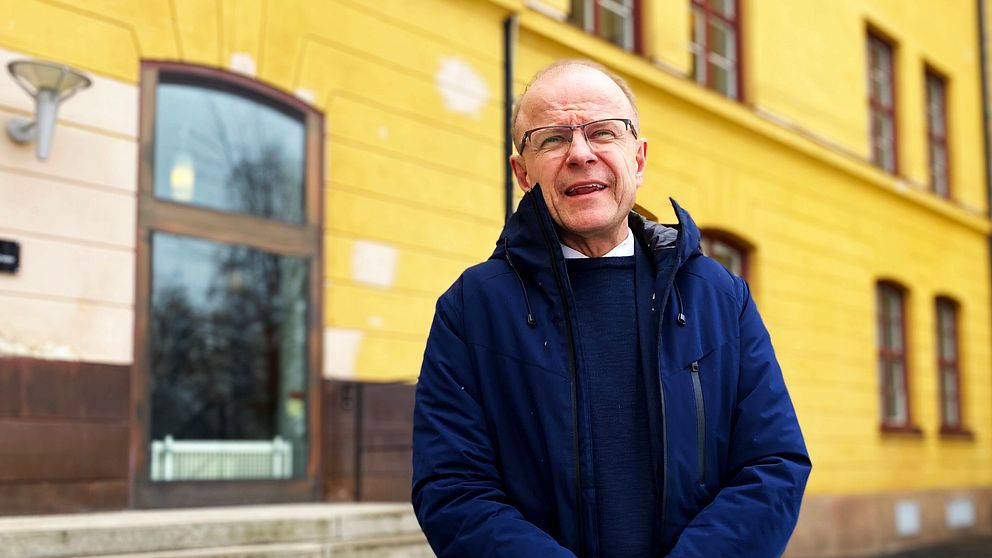 Kristdemokraternas försvarspolitiska talesperson Mikael Oscarsson i Sollefteå står framför en gul garnisonsbyggnad på regementet I21..