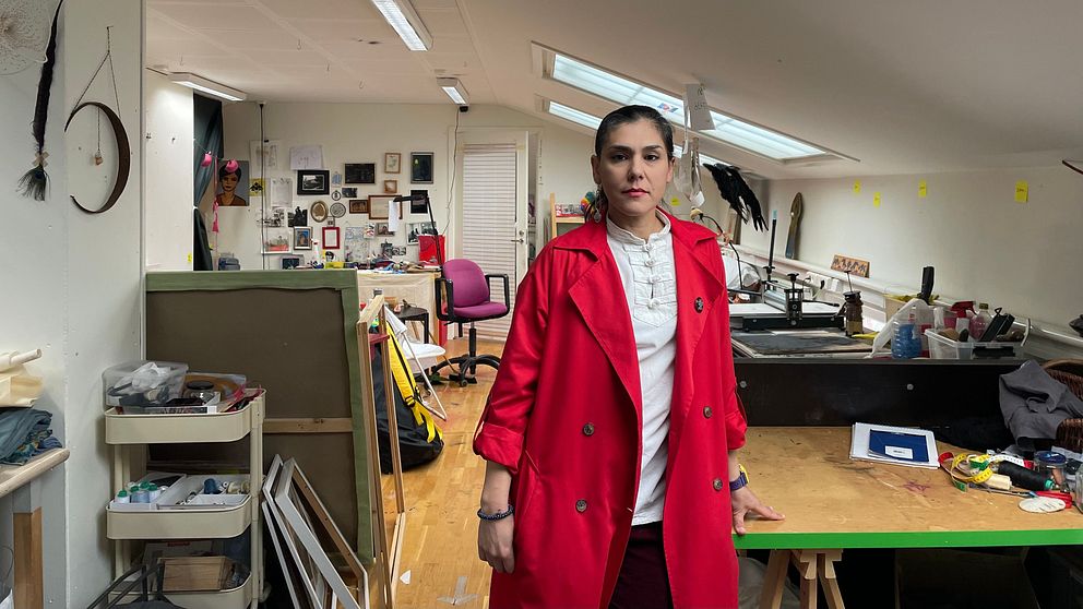Konstnären står i ateljén
