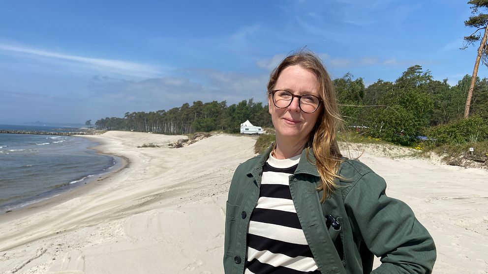 Kvinna står på stranden