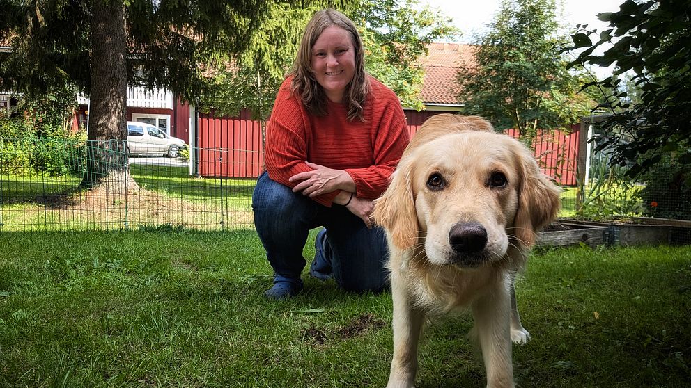 Andréa Olofsson sitter på knä i sin bakgård jämte sin hund Enzo