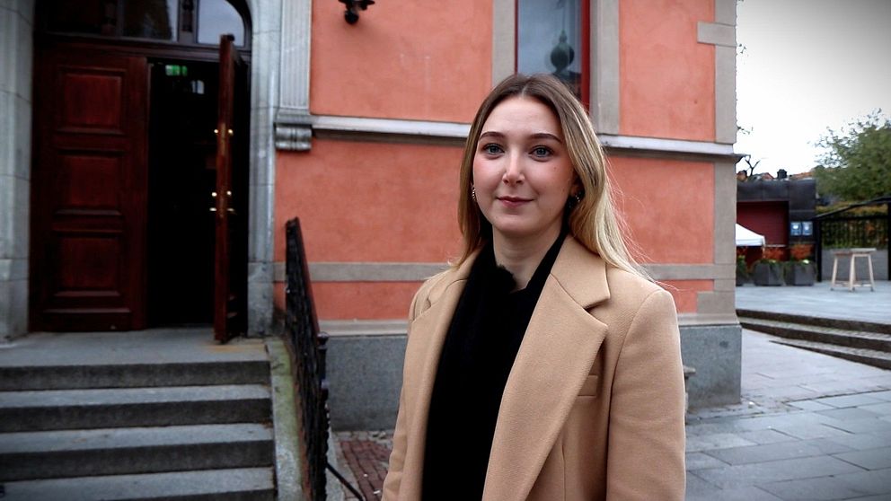 Kvinna framför gammalt hus