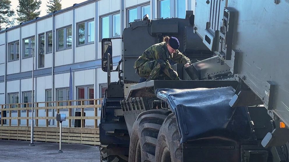 En soldat sitter på en Archer framför kontorsmoduler vid nya A9 i Kristinehamn.