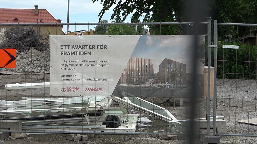 Bygget i Lomma, avspärrat med stängsel och en skylt som visar hur det nya kommunhuset och gymnasieskola ska se ut