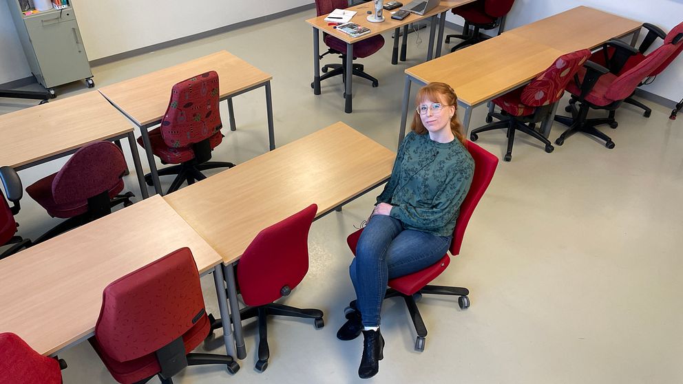 En kvinna sitter ensam i ett litet klassrum