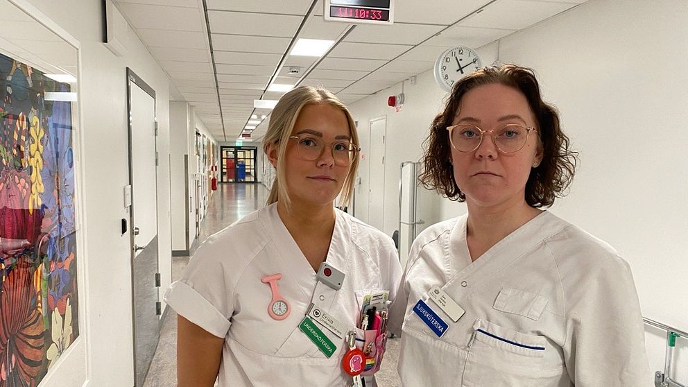 Undersköterskan Erika Karlsson och sjuksköterskan Sara Karlsson Stjärnholm står i en korridor på Kullbergska sjukhuset i Katrineholm.