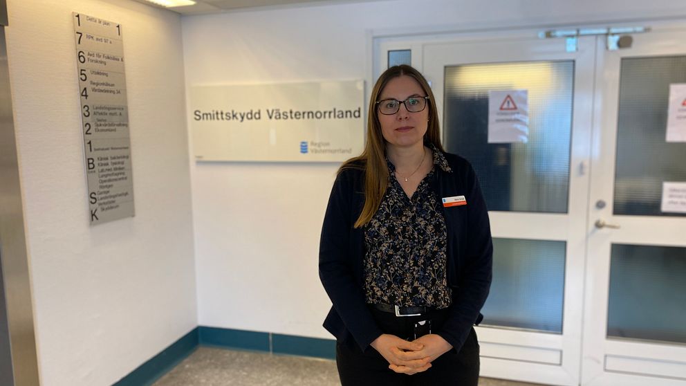 Smittskyddsläkaren i Västernorrland Maria Tempé utanför skylten till smittskyddsenhetens avdelning på Sundsvalls sjukhus