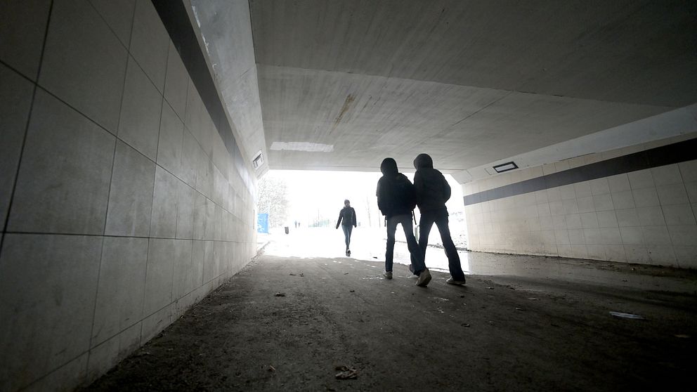 Tre personer går i en tunnel mot starkt ljus framöver.