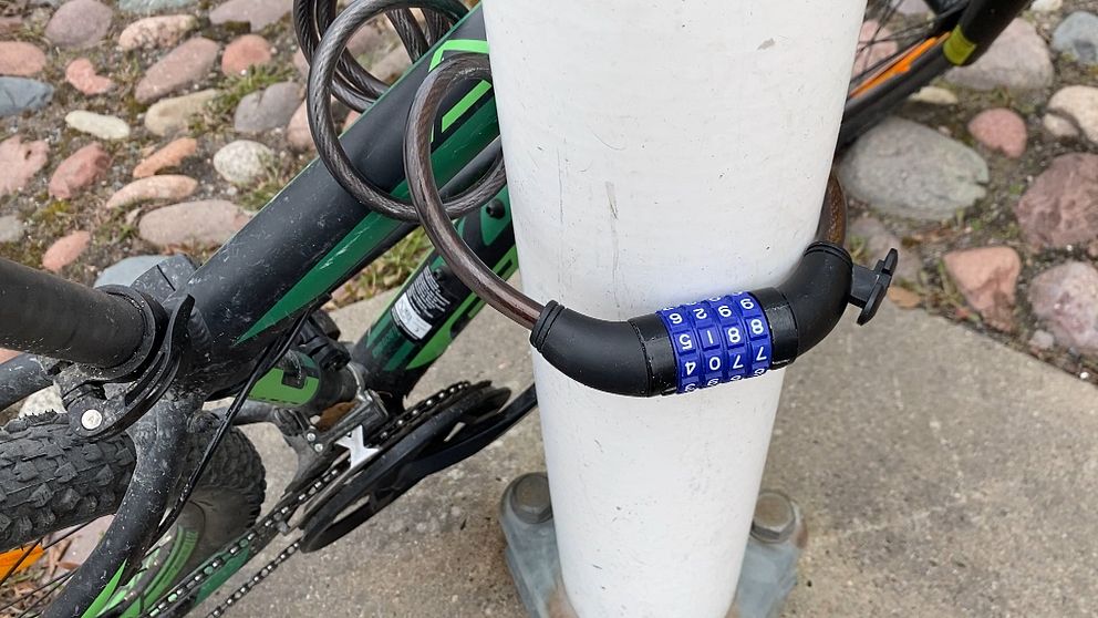 Cykel låst med cykellås runt stolpe