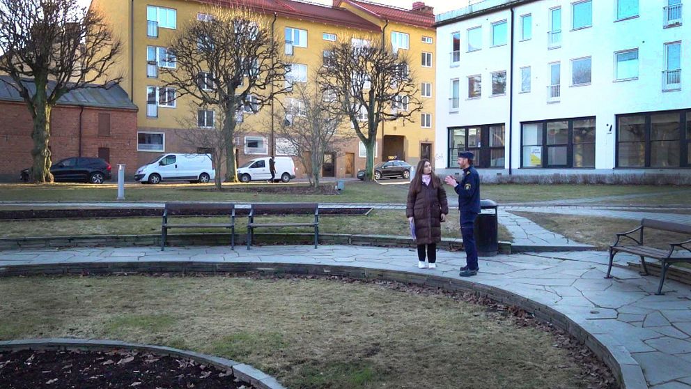 Två personer står i en park.