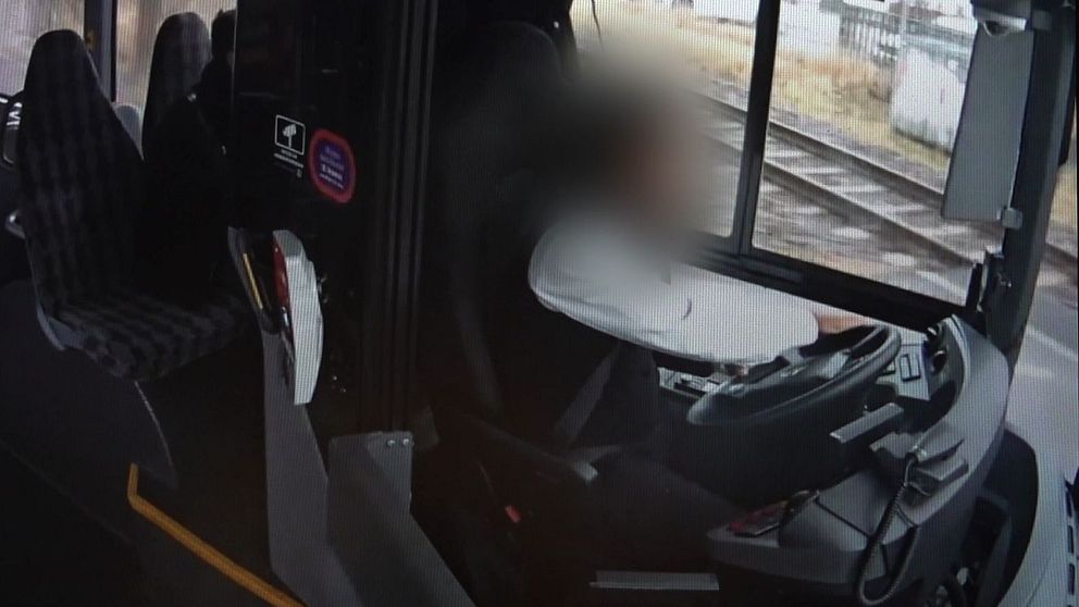 Oskarp bild av bussförare i förarhytten.
