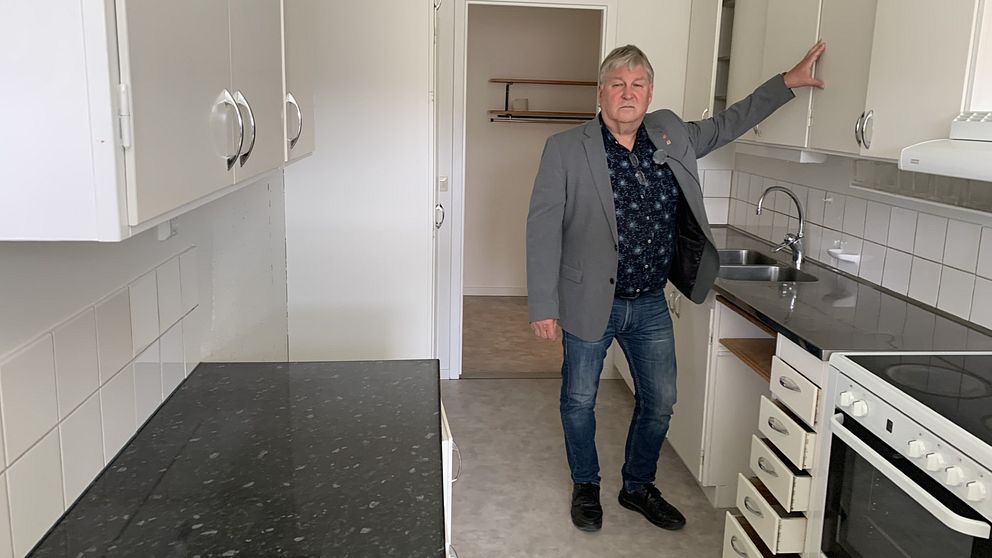 Greger Lindqvist som är kommunalråd i Dorotea står i en tom lägenhet med ett allvarligt ansiktsuttryck.