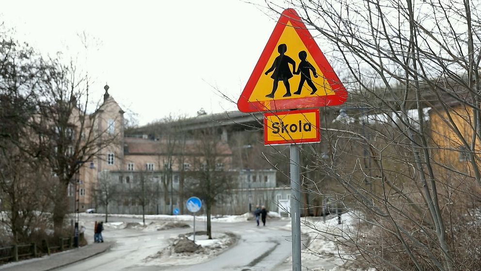 Bild på trafikskylt utanför skolbyggnad.