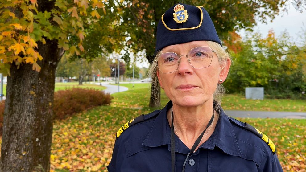 Johanna Hennix, lokalpolisområdeschef i Kungsbacka står framför ett område med färgglada höstlöv och en grön park i bakgrunden.