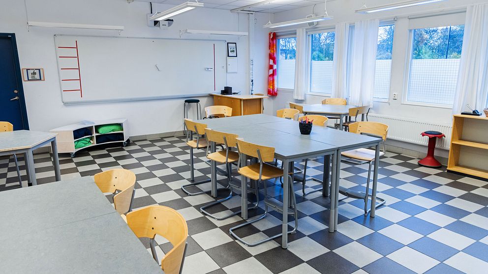 Ett klassrum med bänkar och stolar.