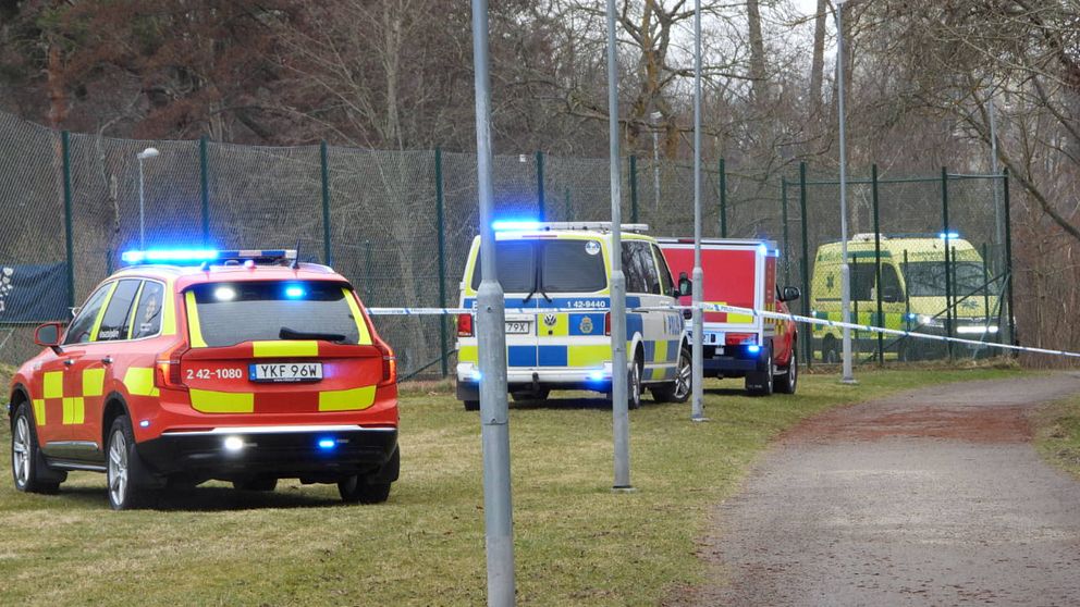 Ambulans och polisfordon med blåljus vid avspärrat område.