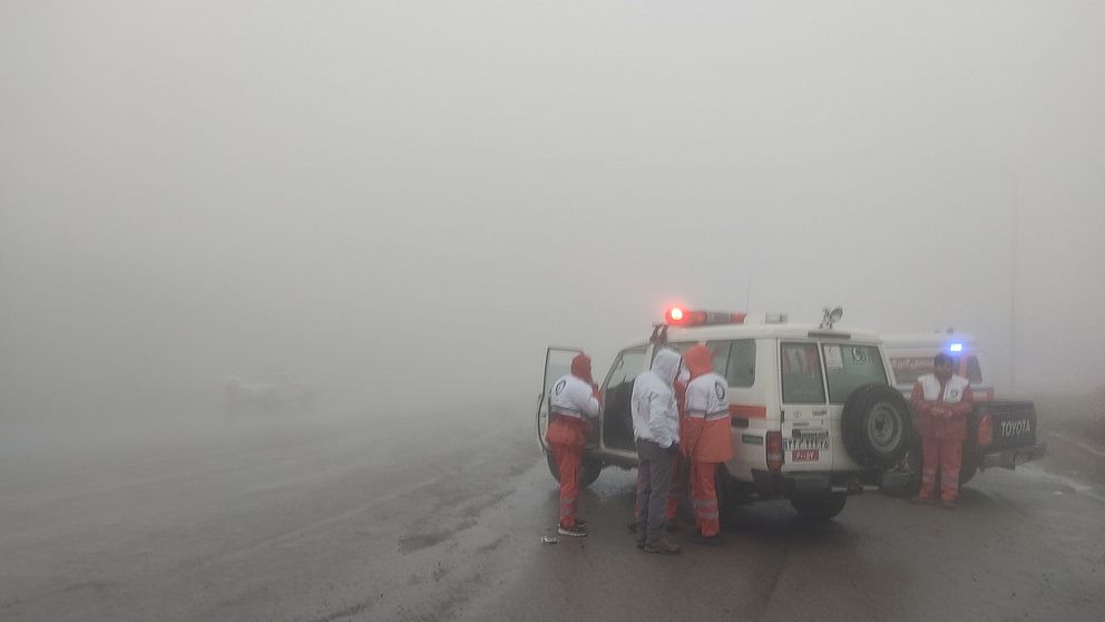 Räddningsarbetare vid en ambulans i tät dimma