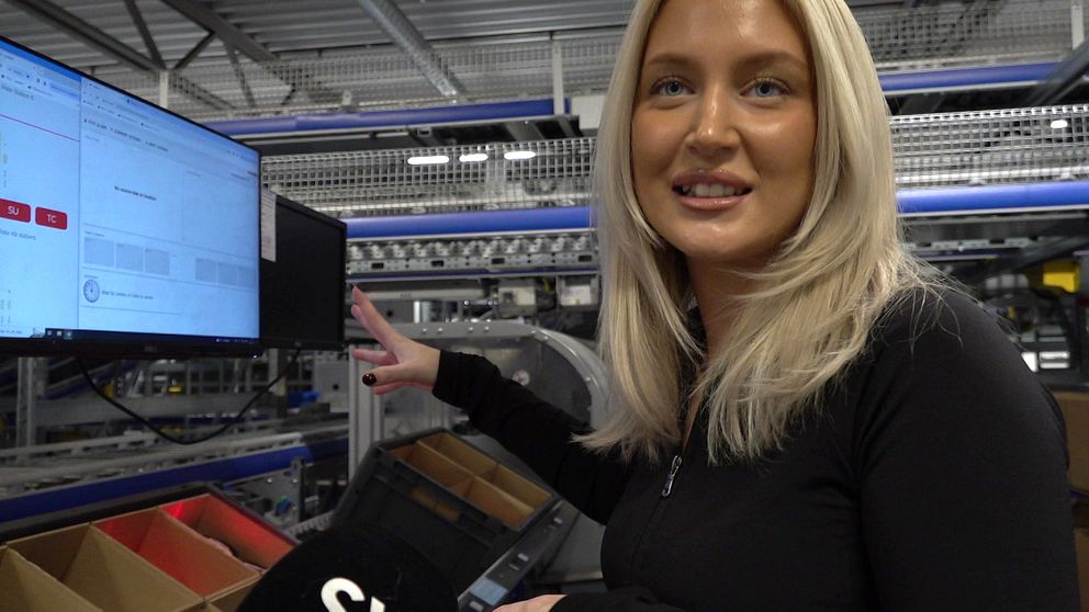 Unga Linn i Vansbro står vid en datorskärm i fabriken och berättar om arbetet.