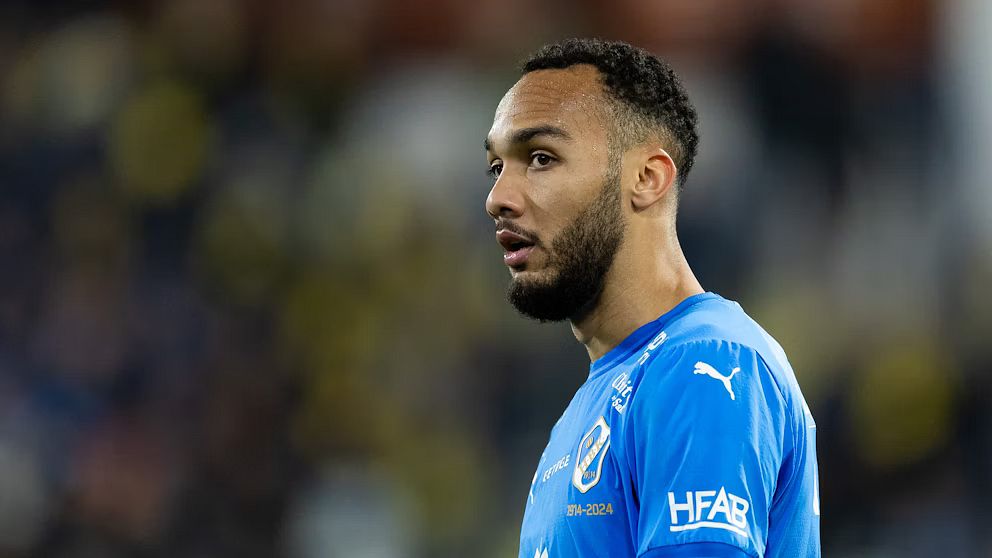 Fotbollsspelare i blå matchtröja under en match.