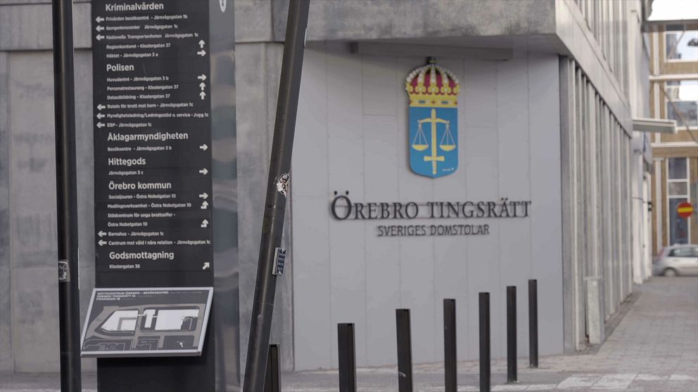 Örebro tingsrätts entré med skylt och Sveriges vapen och namn på fasaden.
