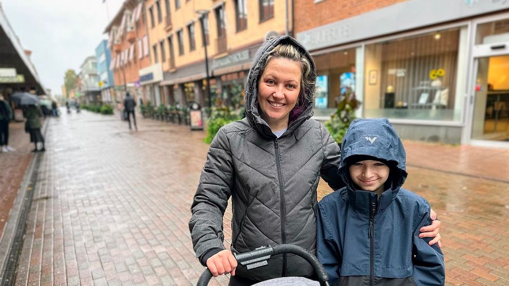 Mamma står med sin son och en barnvagn på gågatan i Skellefteå