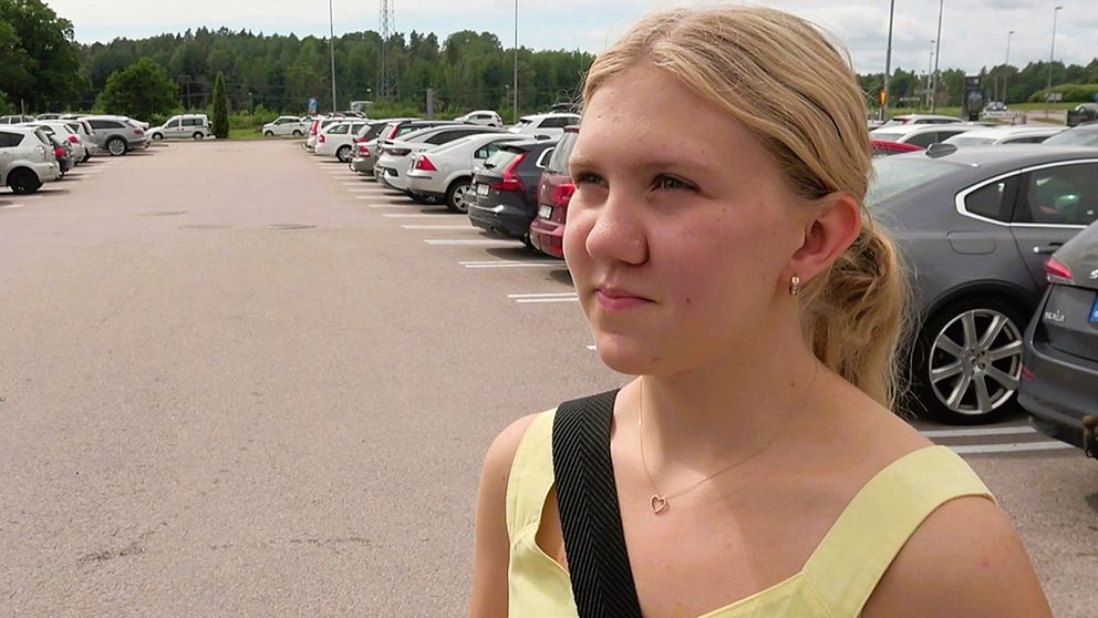 En kvinna blir intervjuad på en parkeringsplats
