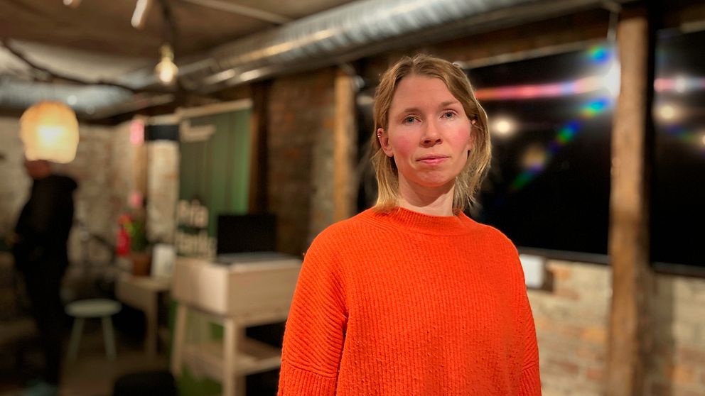 Johanna Barr, kvinna med orange tröja står i en lokal där de nyss hållit en infokväll om gruvplanerna i Jämtland.