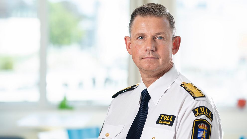 En man i uniform står framför kameran