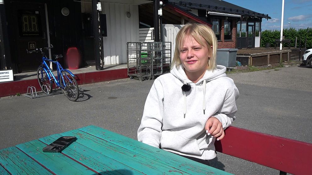 16-åriga Tindra Björkman sitter på en bänk.
