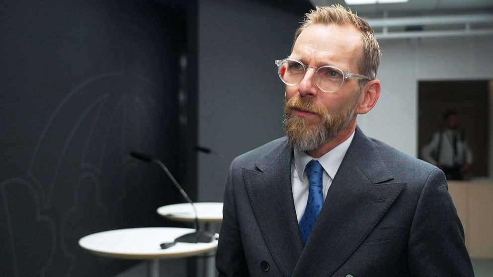 Socialminister Jakob Forssmed svarar på frågor om psykisk ohälsa på en pressträff. Han bär en grå kavaj med blå slips.