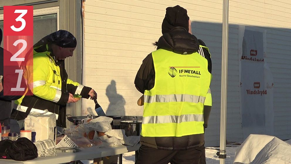 Personer i gula västar där det står ”IF Metall” står utomhus