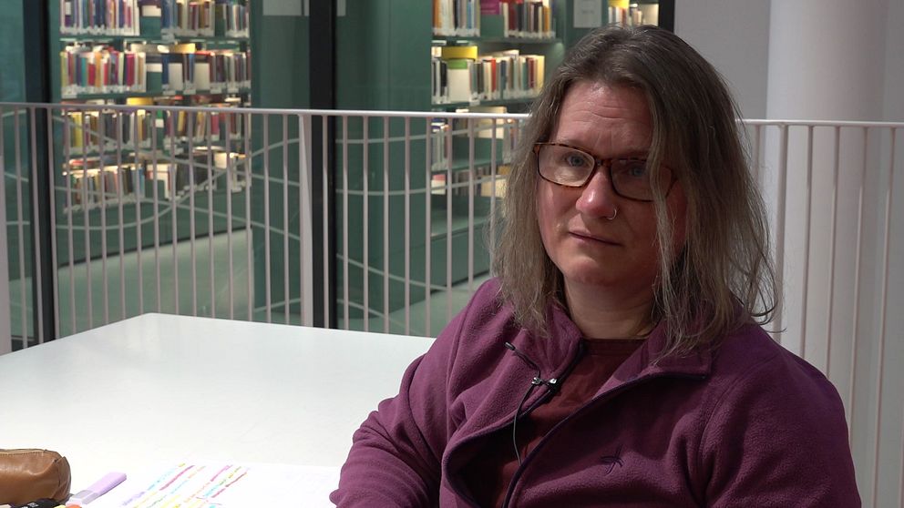 Daniella Graflund sitter vid ett bord inne i biblioteket på Mälardalens universitet