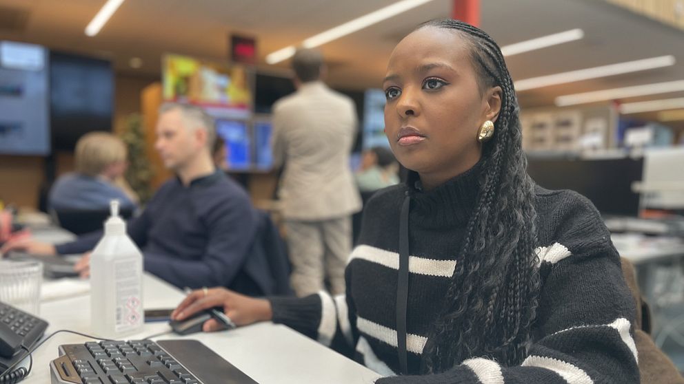 En ung kvinna framför en dator
