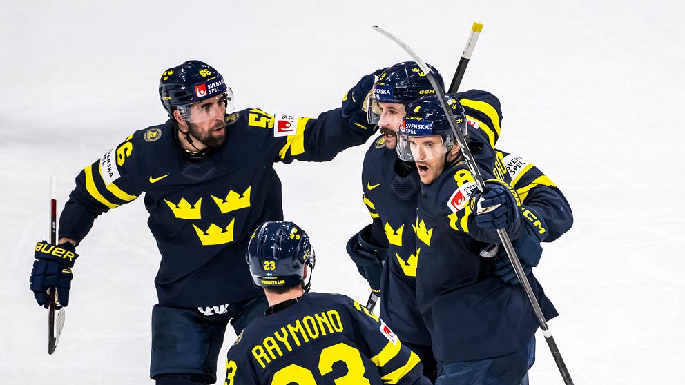 Tre Kronor-spelare firar tillsammans på isen efter en målchans i ishockeymatch.