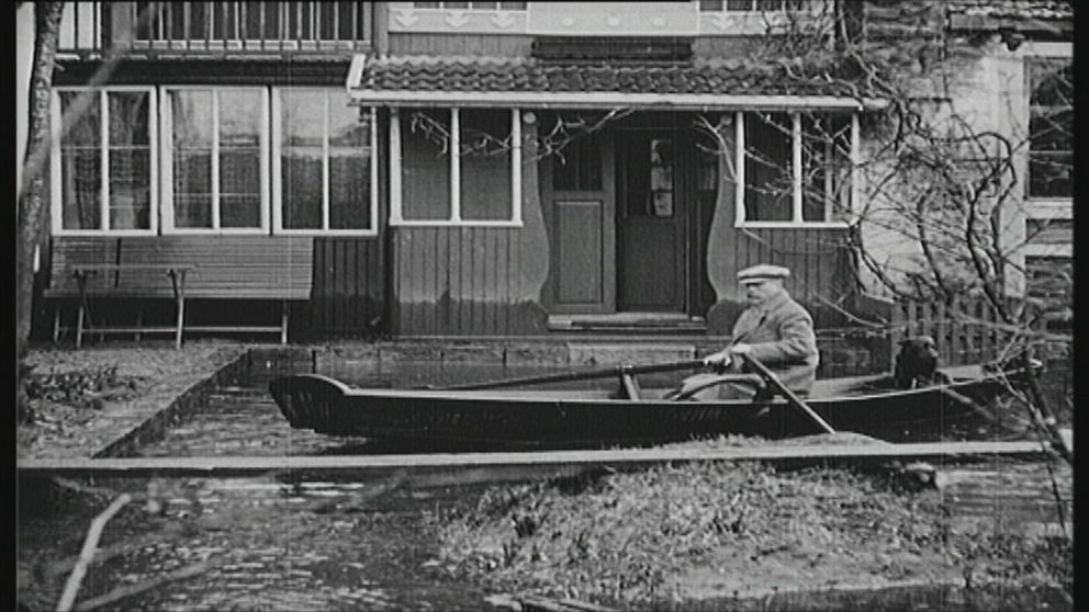 Carl Larsson ror sin båt fram till ytterdörren i Sundborn
