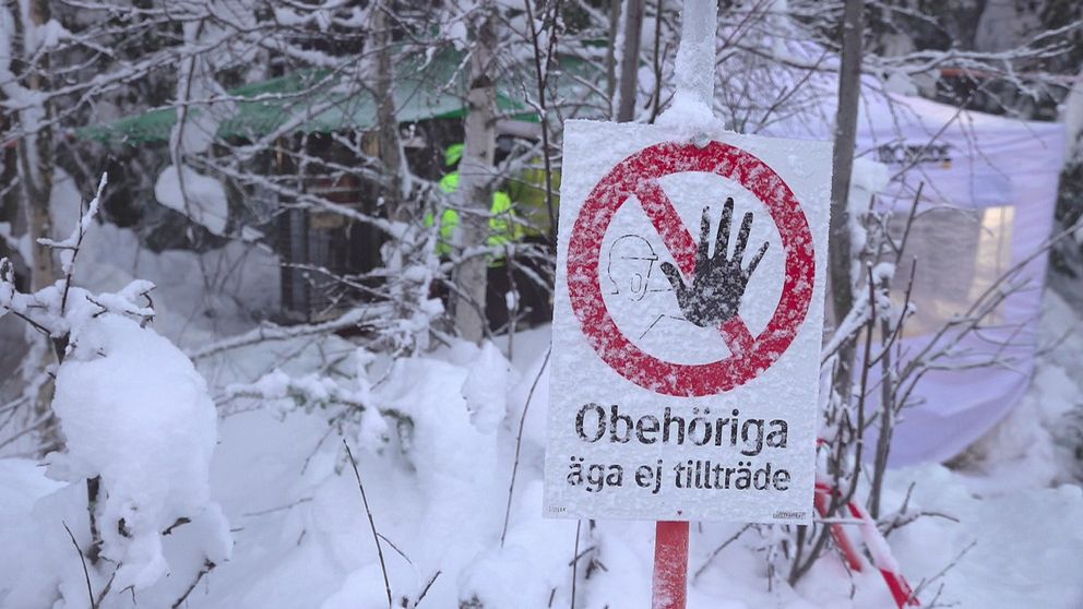 Varningsskylt om tillträdesförbud står i ett snötäckt skogsområde.