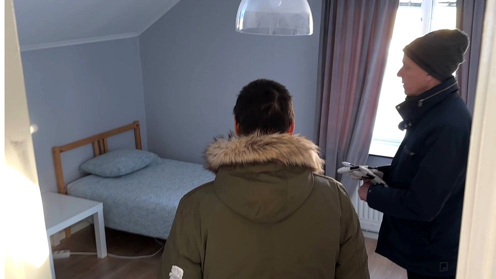 Två personer står och tittar på en säng i ett rum på Skellefteås nya härbärge-
