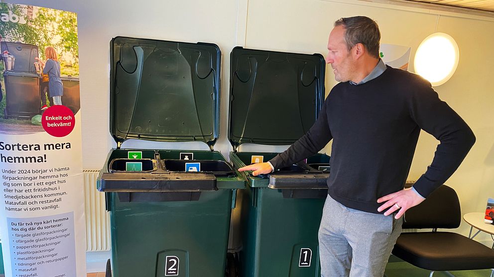 Andreas Boström, ordförande WBAB, står vid två av de nya sopkärlen som har flera små kärl för olika sorters avfall.