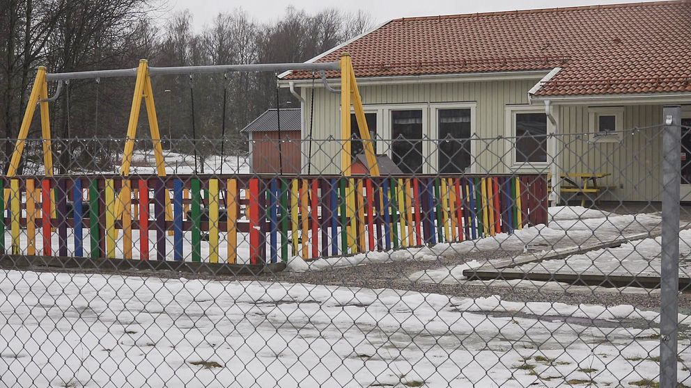 Förskolan Igelkotten, ett ljusgrönt hus med gungor och ett färgglatt staket framför.