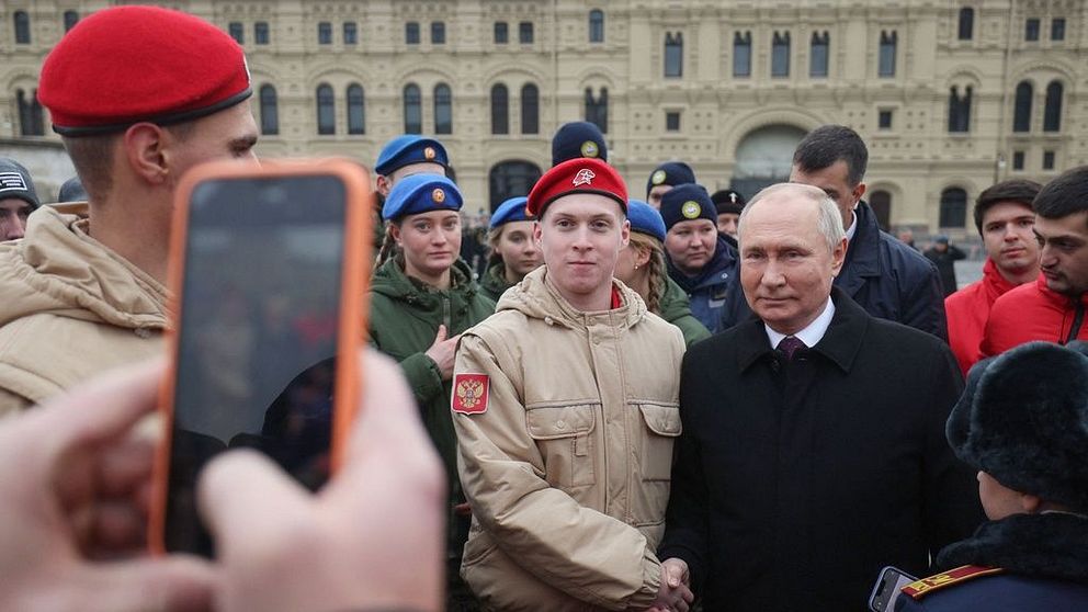 Vladimir Putin skakar hand med en soldat i Moskva.